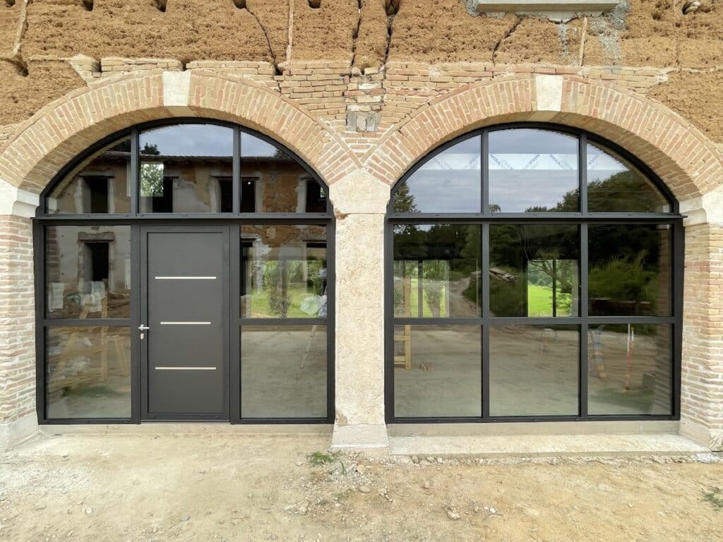 porte d'entrée et verrière dans un bâtiment ancien avec des arches